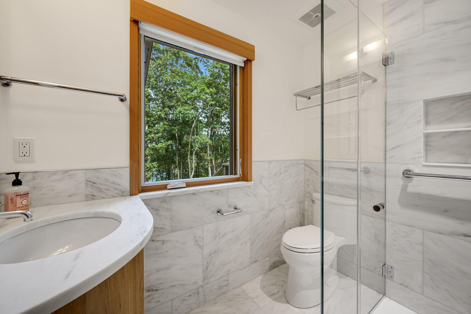  Hall bathroom with marble tile and counter and glass enclosed shower