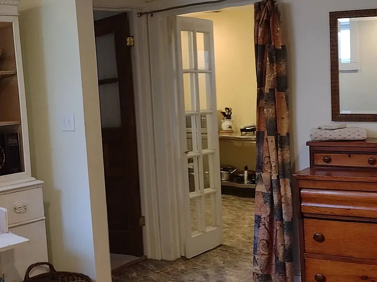Bifold door with privacy curtain leads to kitchenette.