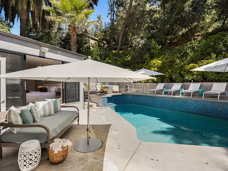 Surrounded by lush landscaping, the pool offers a serene retreat from the bustling city life.