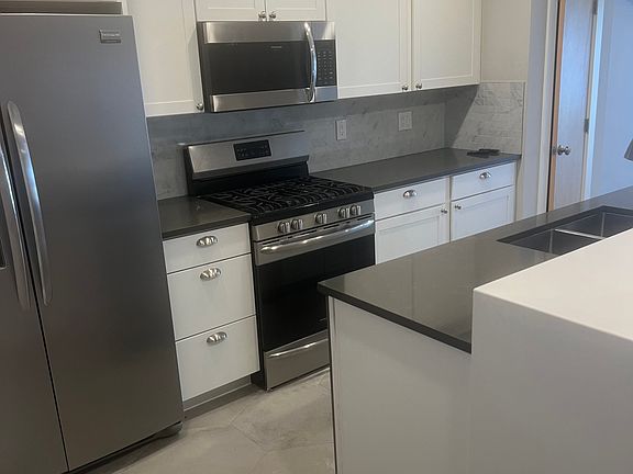 Modern kitchen with new cabinets and floor tile.