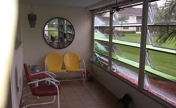 Ample Tiled Lanai with Ceiling Fan - Glass Enclosed - Looking onto Landscaping