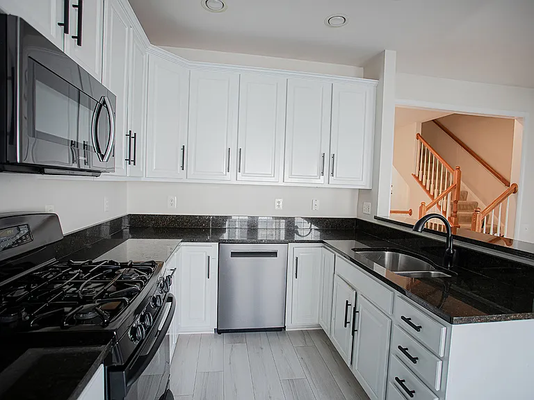 Modern Sleek Kitchen featuring granite countertops and updated stainless steel appliances. Gas stove and functional fridge