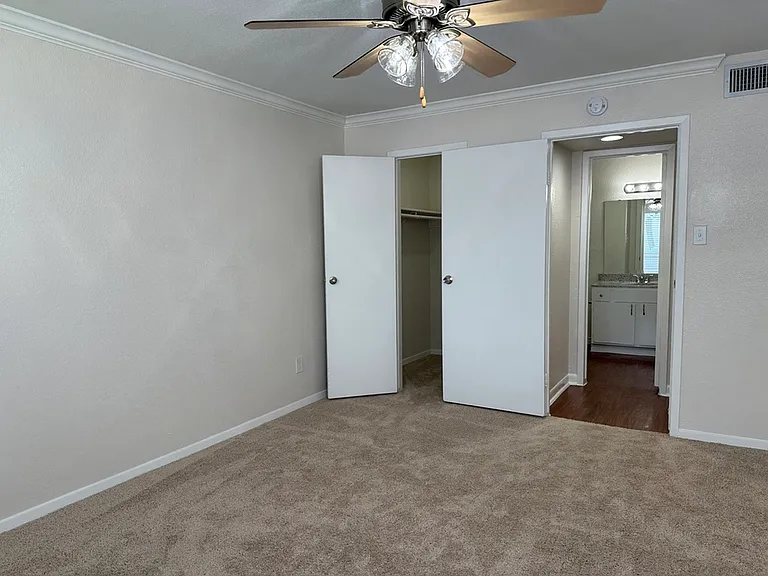 Bright bedroom with a ceiling fan, spacious closet, and convenient access to bathroom featuring modern fixtures. Bright bedroom with a ceiling fan, spacious closet, and convenient access to bathroom featuring modern fixtures.