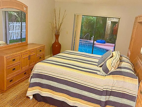 Primary BR with ensuite bathroom boasts private access to pool, yard and spa, king size bed, high ceilings and plenty of closet space