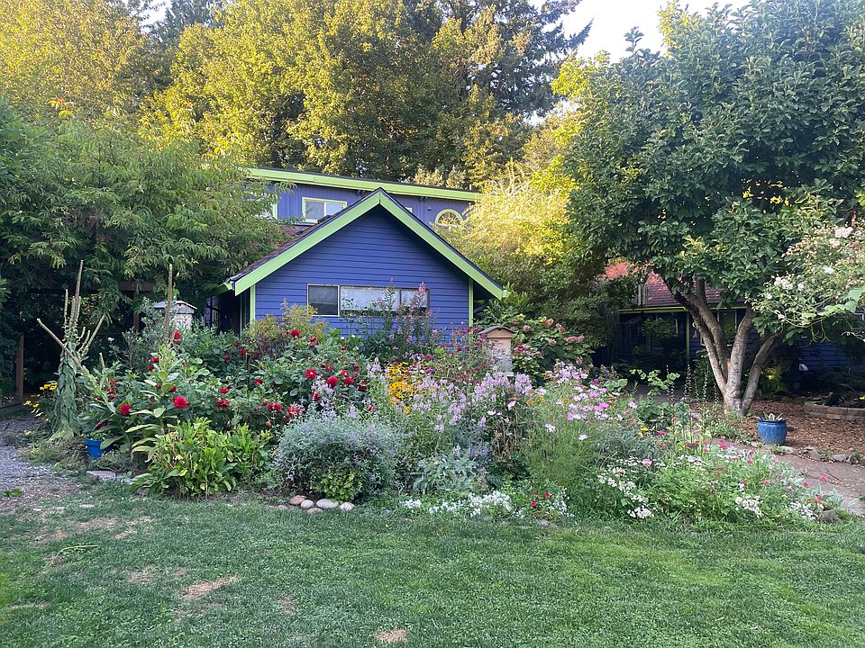 View of our home from the front yard (down a very long driveway behind a gate). One acre oasis!