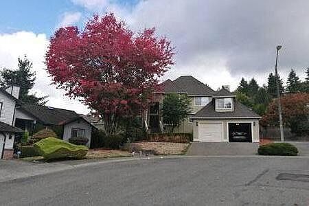 Tucked behind a beautiful maple tree, front of the house, two-car garage, front entry to the left
