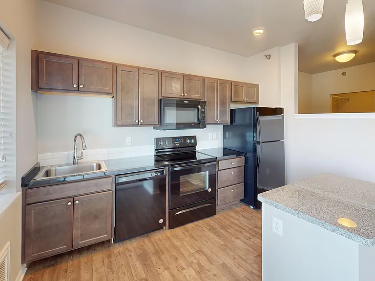 The Poppy is a studio apartment featuring a large kitchen space with a kitchen island, dishwasher, and range. The Poppy is a studio apartment featuring a large kitchen space with a kitchen island, dishwasher, and range.