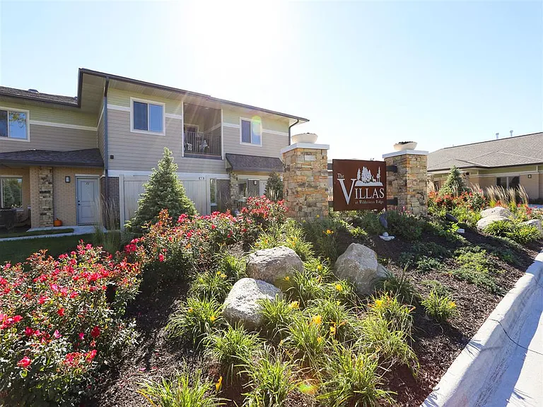 Lush landscaping and natural stone accents create a warm welcome home.