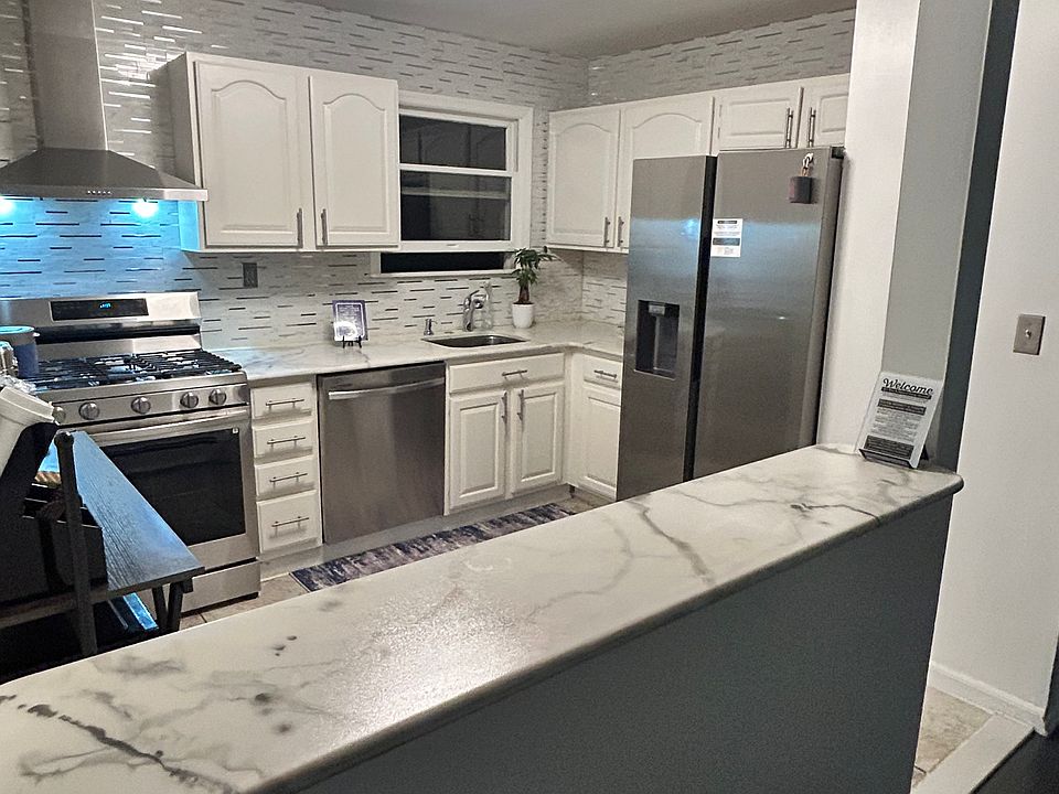 Experience the heart of the home in this newly renovated kitchen, boasting sleek new appliances and a charming small island that seamlessly separates yet connects the living and dining areas for an open, inviting flow.