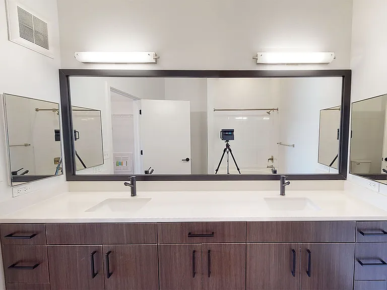 Apartment Bathroom with large soaking tub, wood-style flooring and double sinks.