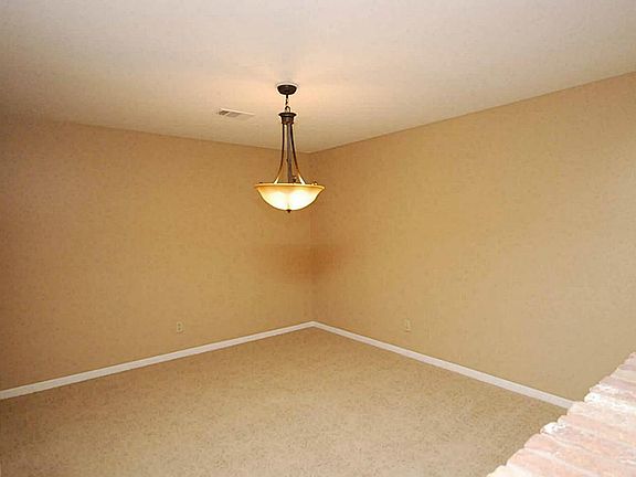 Elegant Formal Dining with fresh designer paint, new light fixture and never lived on carpets.