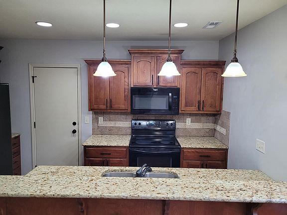 Renovated kitchen with granite counter tops and custom lighting