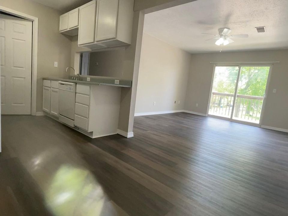 Living Room and Balcony view from Kitchen, with Separate Private Laundry Room off Kitchen.