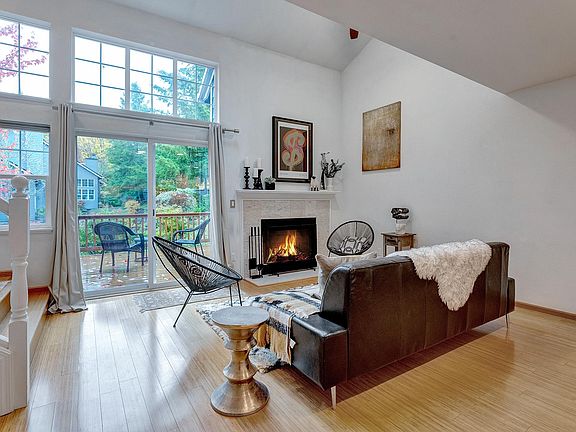 Living room with vaulted ceilings, fireplace, view to deck and private pond