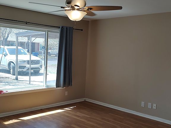 Living room with ceiling fan, picture window, cable-ready, easy-clean vinyl plank floors throughout.