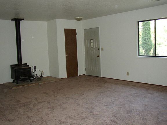 Wood stove takes 18" logs. Room faces east.