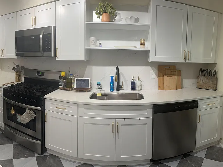 Updated kitchen with shaker cabinets, stainless appliances, ample counter space, and an undermount sink beside a window.