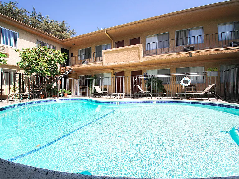 View of gated community pool with lounging space.