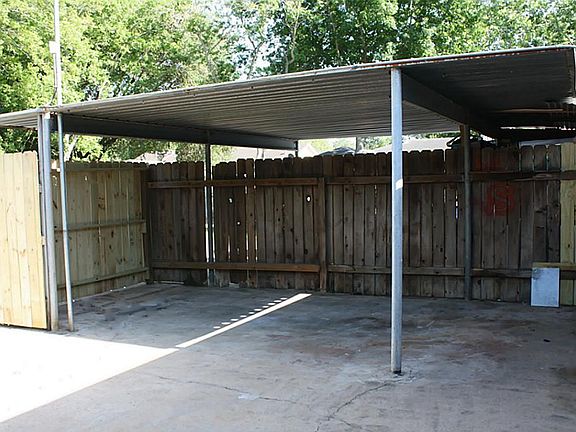 Cover carport in the back of the town home within the partially fenced area.  Also, extra parking in the back.