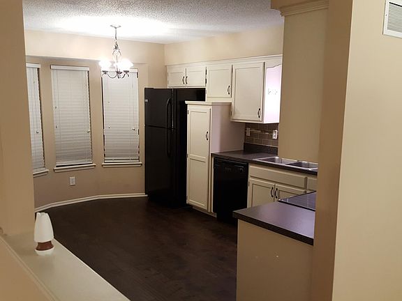 Kitchen comes provided with matching black appliances including refrigerator