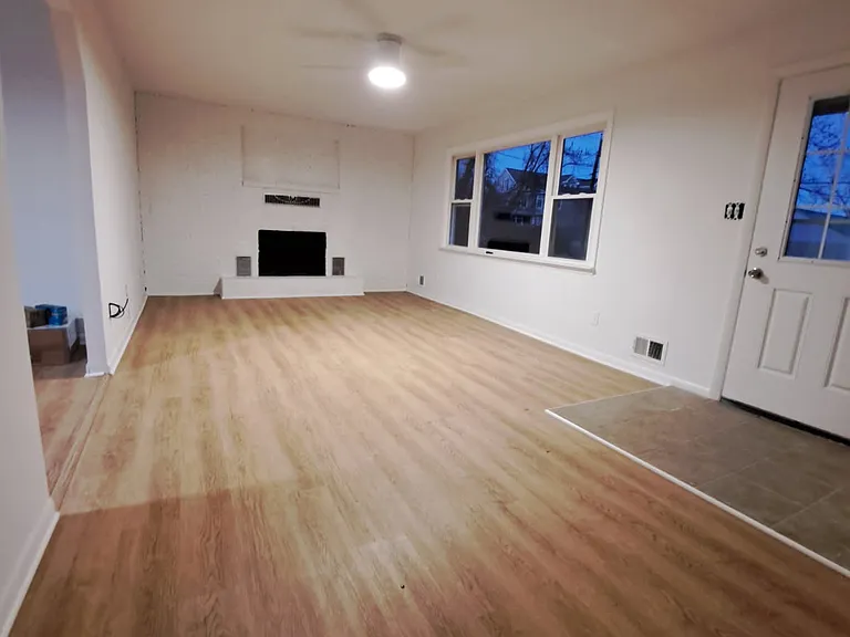 Large living room with wood burning fireplace and water views out the door and windows.