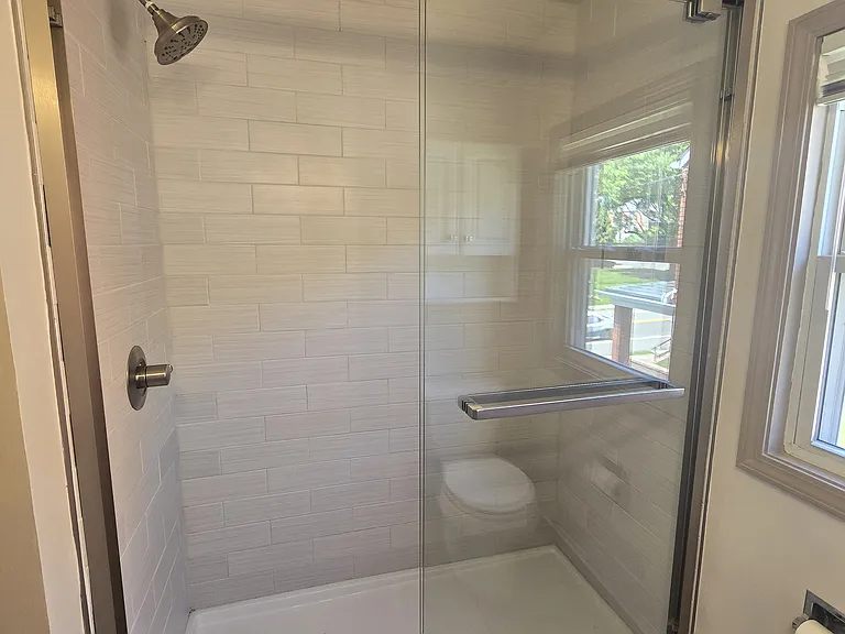 Tiled walk in shower with niche.