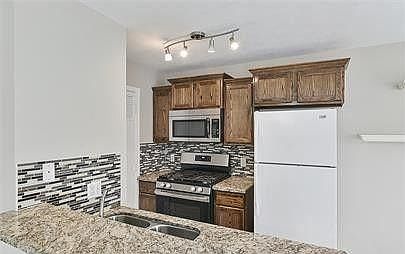 Kitchen includes granite counters, tile backsplash, microwave, dishwasher and gas range!