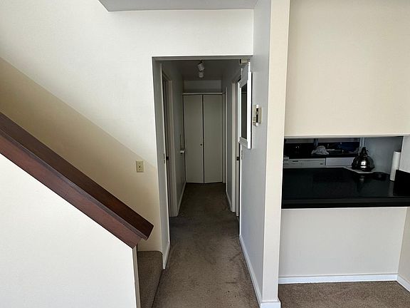 First floor hallway from living room. Access to first bedroom, kitchen and bathroom, with hallway storage