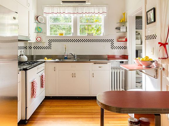 Adorable kitchen includes stainless steel counters, metal cabinets, 1940s Anderson gas stove, and original hardwood floor. No dishwasher or garbage disposal.