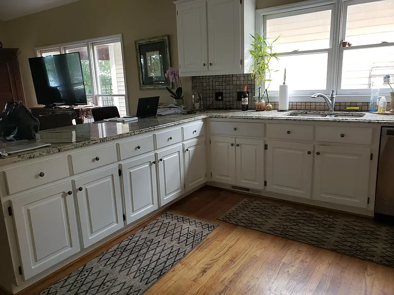 Wide bar seats for 3, hardwood floors. Appliances are stainless steel.