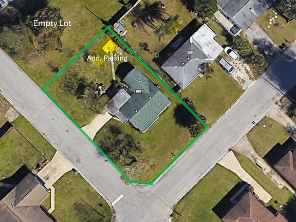 Aerial view of the corner lot showing empty lot for added space and the space marked in yellow for optional designated trailer/toy parking.