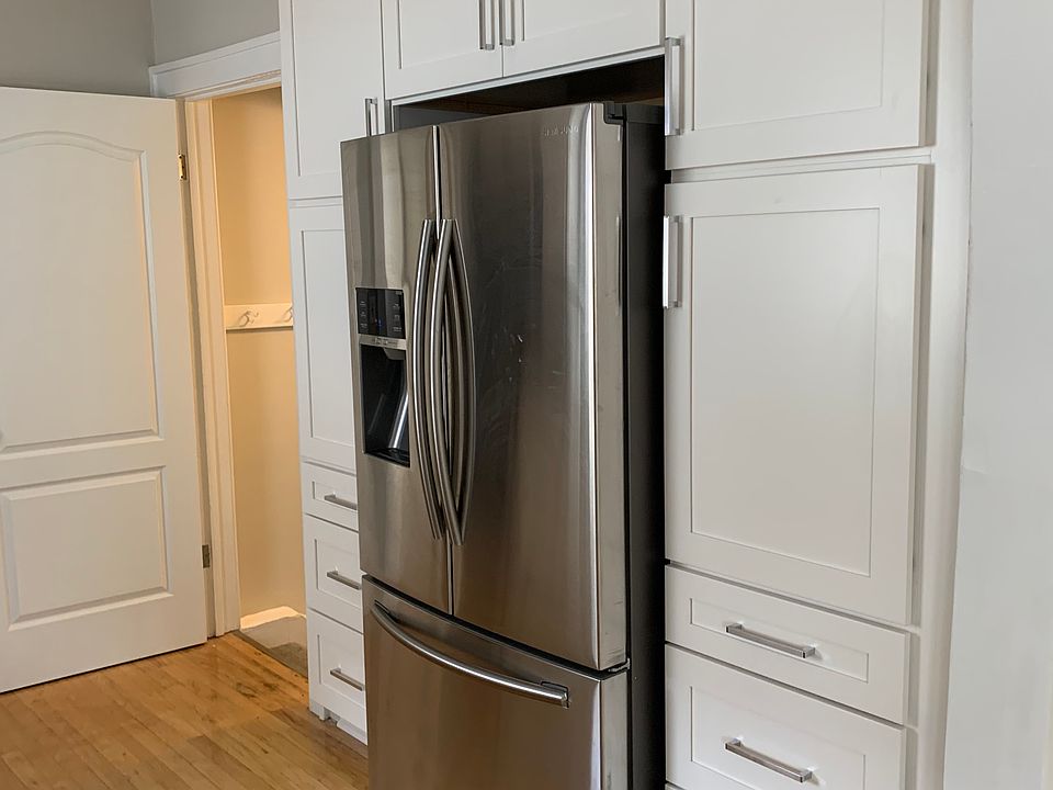 Right side of Kitchen, showing fridge and opening leading to back door and basement.