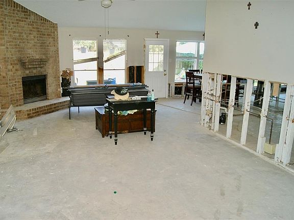 Open floor plan with spacious Living Room boasting a high, vaulted ceiling and a fireplace.