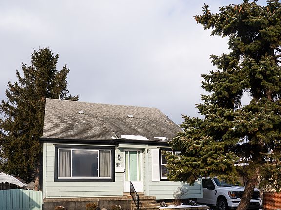 Front of house , including fence and pines that give shade to the back of the home.