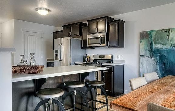 White Cabinets, grey counter top and brown/grey flooring.
