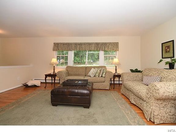 Sun filled living room with gleaming hardwood floors.