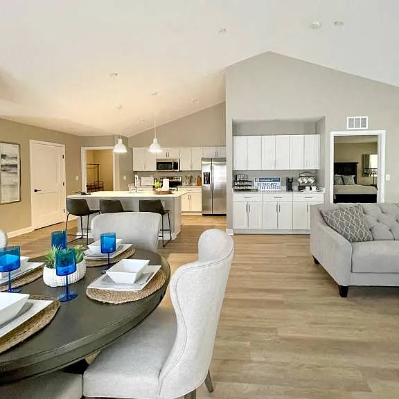 Interior of Champion Reserve Townhomes showing view from far side of dining area towards kitchen and coffee bar and cathedral ceiling.