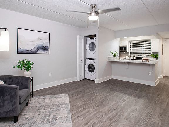 Floor plans feature open-concept living areas featuring stylish wood-style flooring, a ceiling fan, and a convenient in-unit washer and dryer.