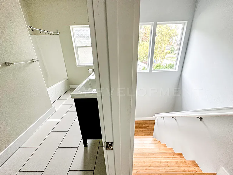 Second Bathroom with Bathtub to the left. Staircase going downstairs to the right.