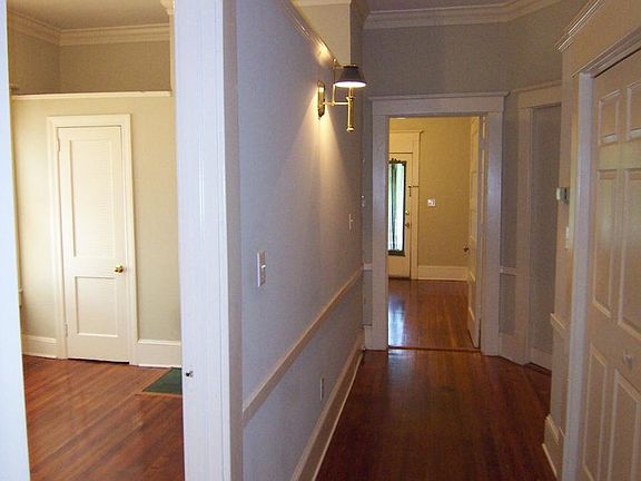 View from bathroom hallway looking into bedroom on left and