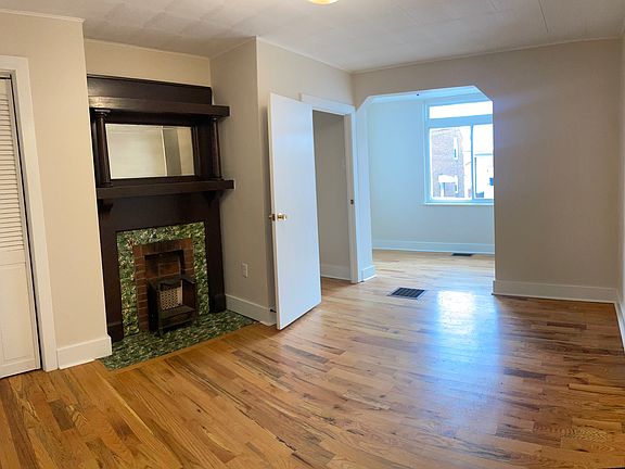 Front sitting room with original mantle, powder room, and a sunny home office space.