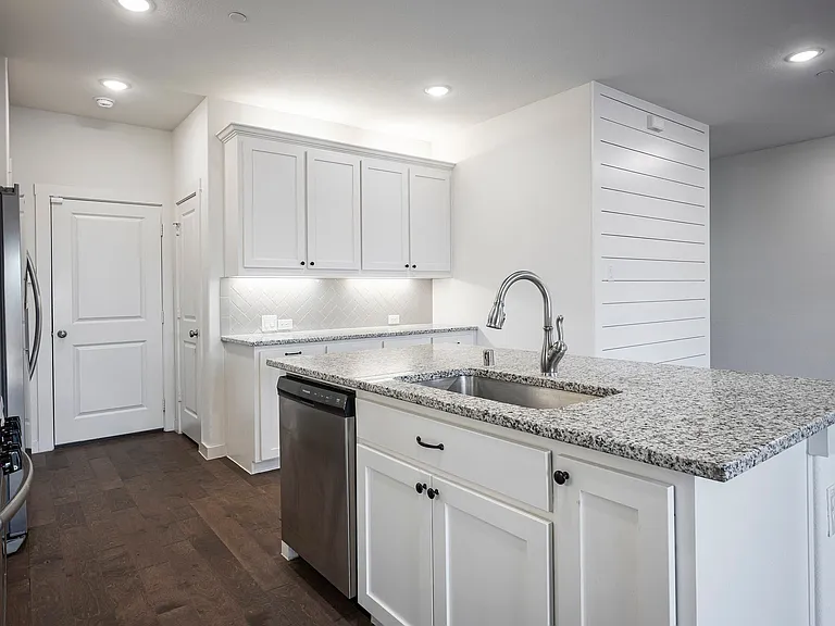 Abundant cabinet space with granite island and undercabinet lighting.