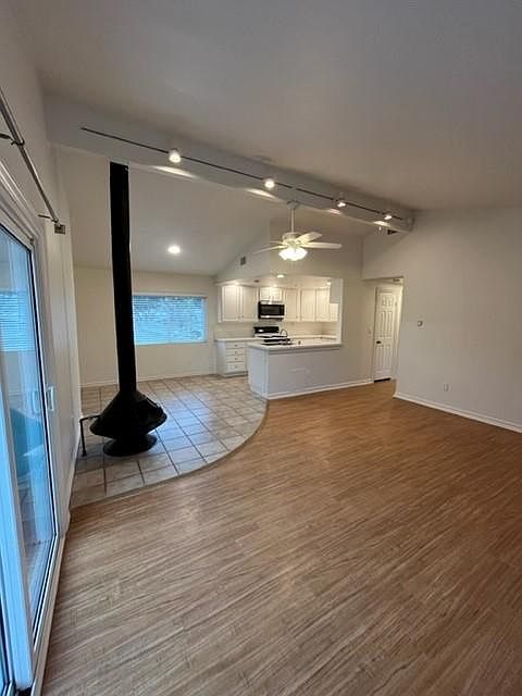 Open concept living room, dining room and kitchen with high ceilings lots of natural light and fireplace.