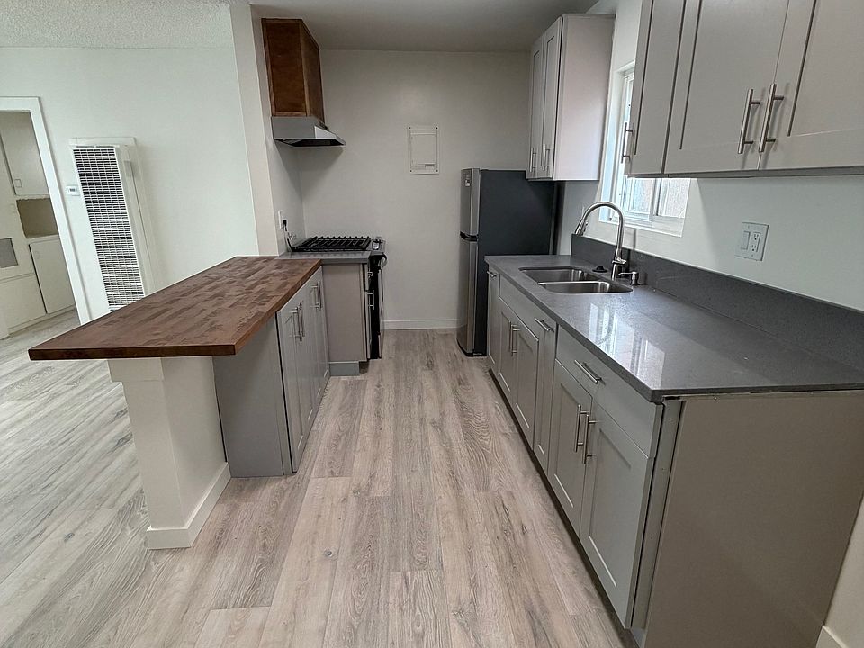 Remodeled kitchen with new range, refrigerator/freezer, countertops, cabinets, sink and bar.