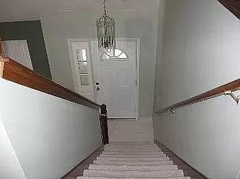 Front door View from inside : stairs leading from front door to upstairs to three bed rooms and two bath rooms.