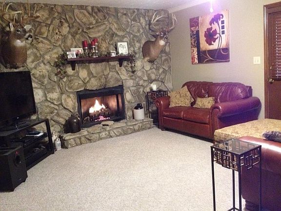 Family room with stone wall and fireplac