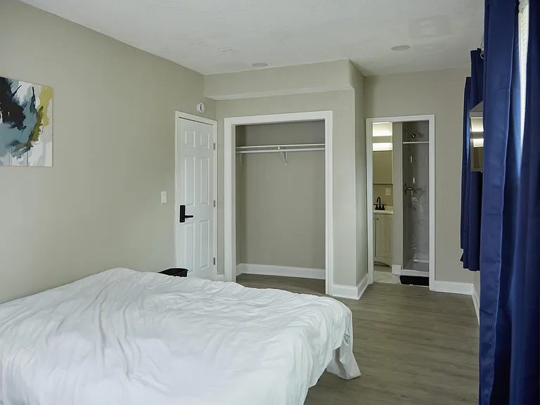 Private bedroom with a large open closet and convenient access to an en-suite bath; neutral finishes and durable flooring.