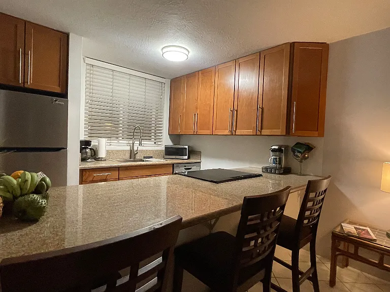 Bar top eating area & kitchen. Stainless steel appliances.