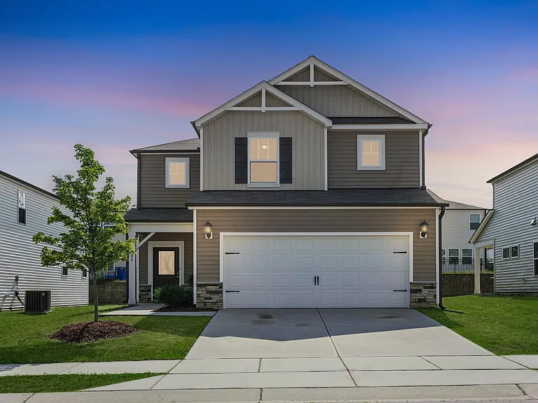 Home front view with an oversized garage and driveway. A sidewalk gives yardage at no extra cost !
