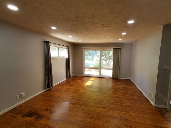Living room towards front of house with hardwoods floors and can lighting